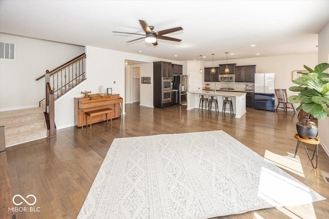 living area with visible vents, dark wood-type flooring, recessed lighting, stairway, and ceiling fan