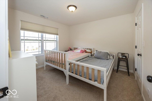 carpeted bedroom featuring visible vents and baseboards