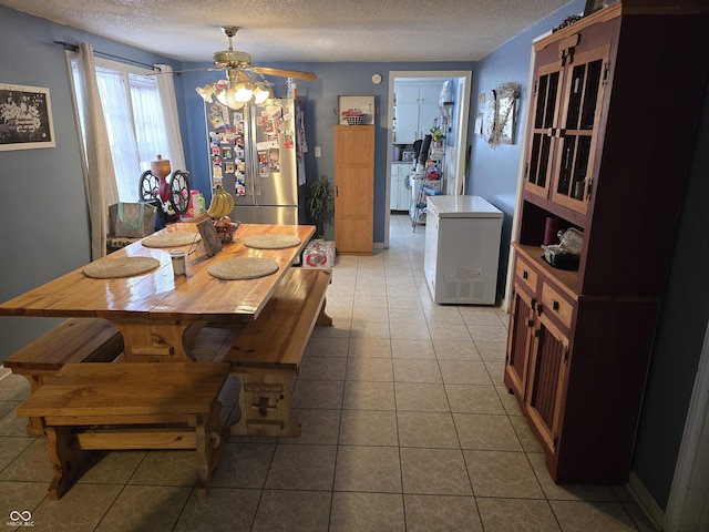 dining room with ceiling fan, light tile patterned floors, and a textured ceiling