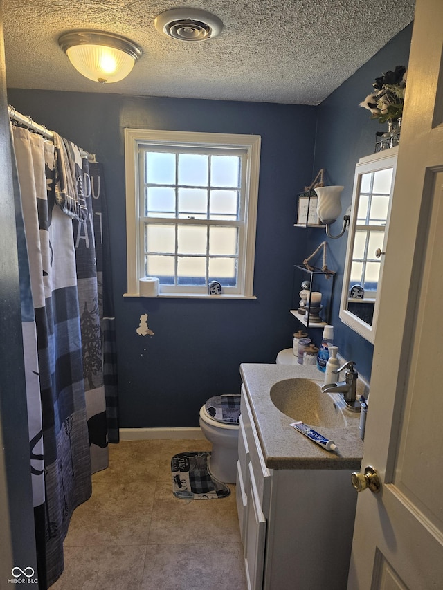 bathroom with visible vents, toilet, a textured ceiling, baseboards, and vanity