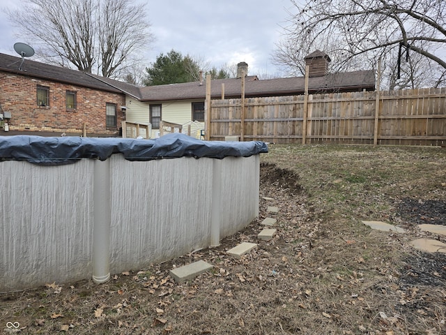 view of yard with fence and a fenced in pool