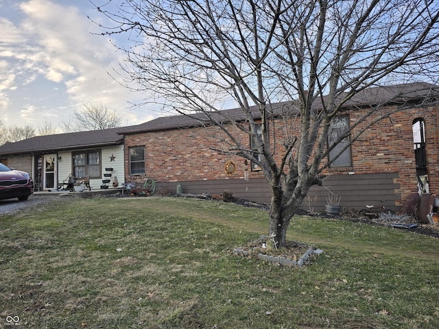 single story home with brick siding and a front lawn