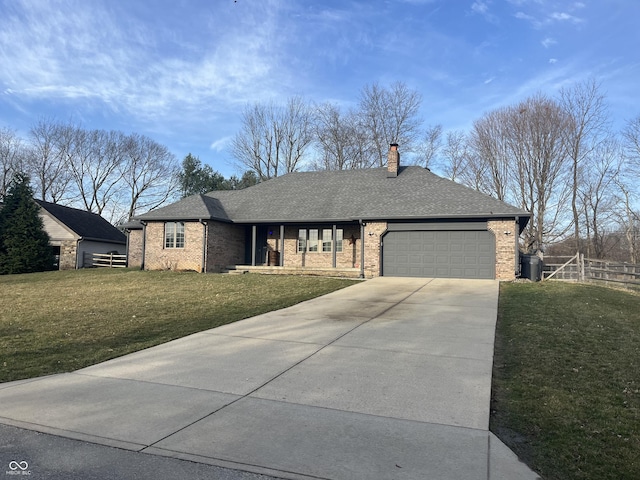 view of front of home with a front yard, driveway, roof with shingles, an attached garage, and a chimney