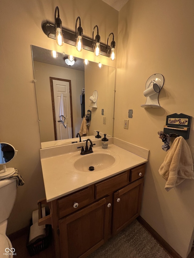 bathroom with vanity, toilet, and baseboards