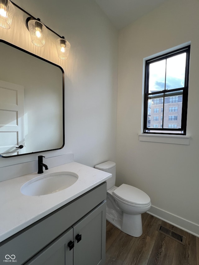 457 Mariposa Trl, Carmel, IN 46032 - bathroom featuring wood finished floors, vanity, toilet, and baseboards