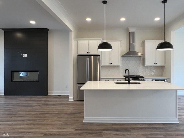 457 Mariposa Trl, Carmel, IN 46032 - kitchen with freestanding refrigerator, wall chimney range hood, a sink, white cabinetry, and crown molding