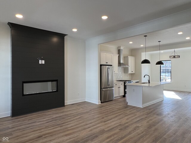 457 Mariposa Trl, Carmel, IN 46032 - kitchen featuring stainless steel appliances, wall chimney range hood, baseboards, dark wood-style flooring, and white cabinets