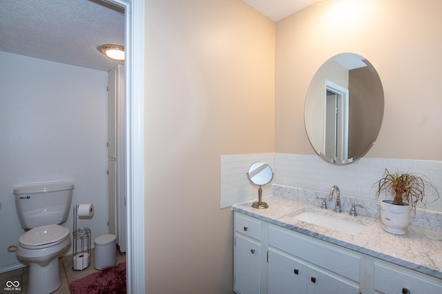 bathroom featuring tile patterned floors, toilet, vanity, and a textured ceiling