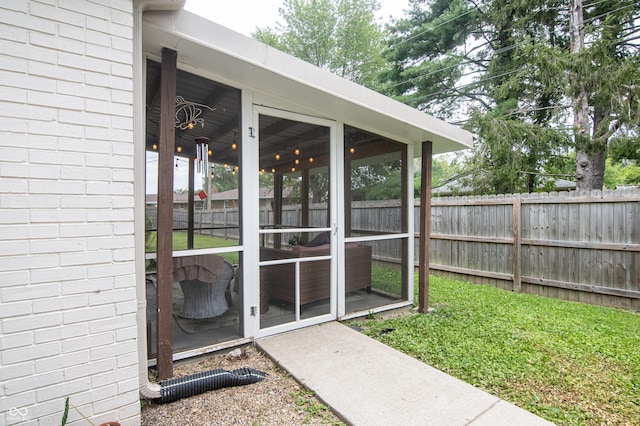 doorway to property with brick siding and fence