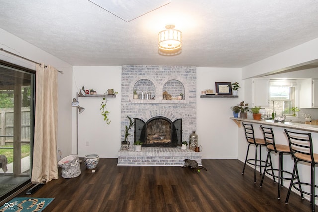 living room with a fireplace, wood finished floors, and a textured ceiling