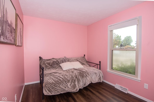 bedroom featuring wood finished floors, visible vents, and baseboards