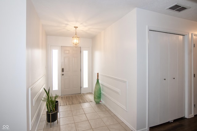 foyer entrance with light tile patterned floors and visible vents