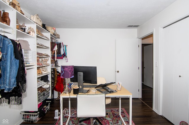 office with visible vents, a textured ceiling, and wood finished floors