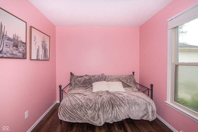 bedroom with wood finished floors and baseboards