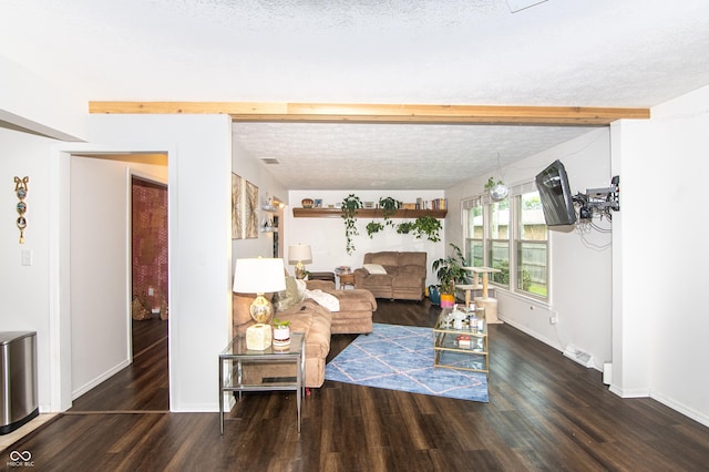 living area featuring visible vents, beam ceiling, a textured ceiling, wood finished floors, and baseboards