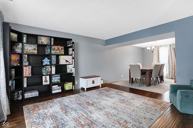 interior space featuring baseboards, wood finished floors, and a chandelier