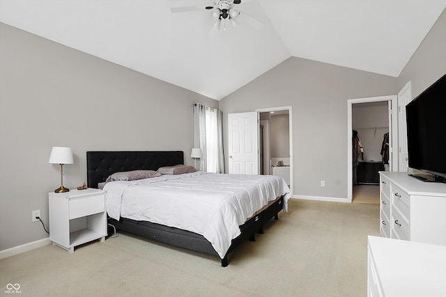 bedroom featuring light carpet, a spacious closet, a closet, and vaulted ceiling