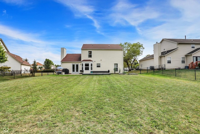 back of property with a patio, french doors, a lawn, and a fenced backyard