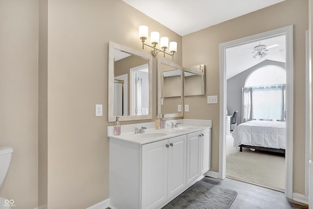 full bath with double vanity, connected bathroom, a ceiling fan, and a sink