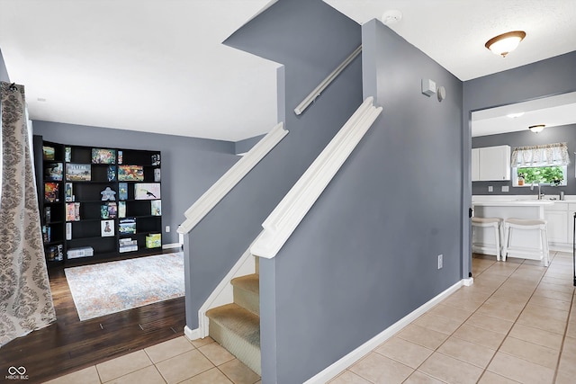 stairs with tile patterned floors and baseboards