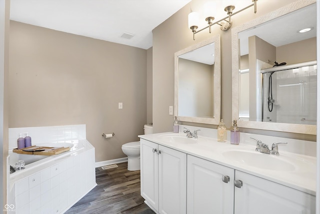 full bath with toilet, wood finished floors, a stall shower, and a sink