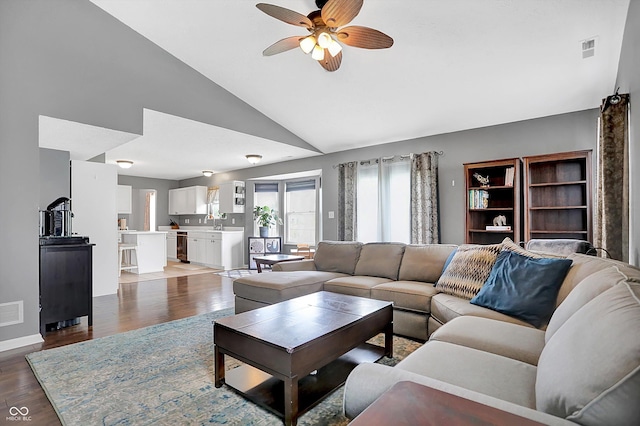 living room with visible vents, lofted ceiling, wood finished floors, and a ceiling fan