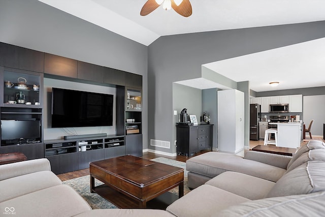 living area with baseboards, visible vents, ceiling fan, vaulted ceiling, and light wood-type flooring