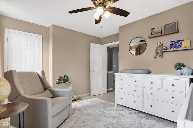 sitting room with light colored carpet, baseboards, and ceiling fan