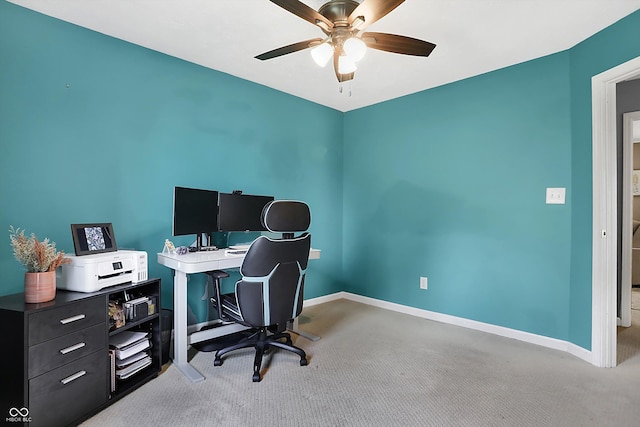 carpeted office with baseboards and ceiling fan