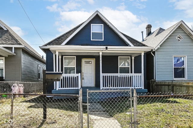 bungalow-style home with a fenced front yard, a porch, and a gate