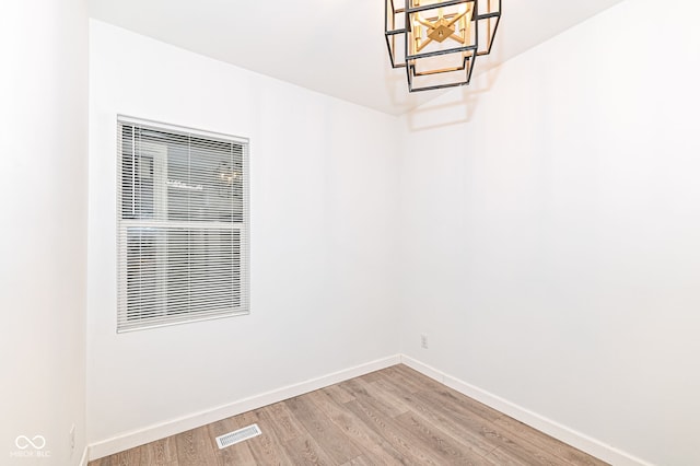 empty room featuring visible vents, baseboards, and light wood-style floors