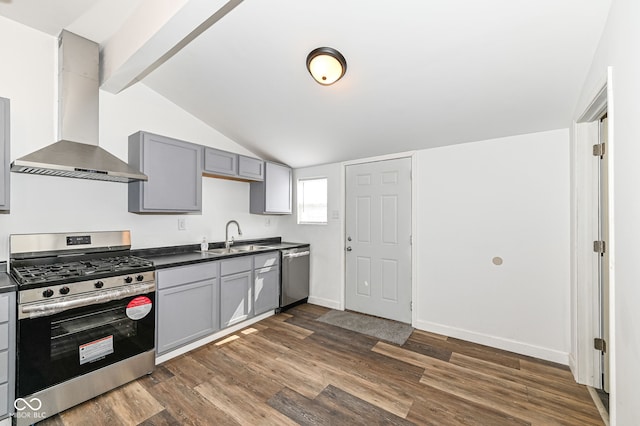 kitchen with dark countertops, appliances with stainless steel finishes, gray cabinetry, and wall chimney range hood