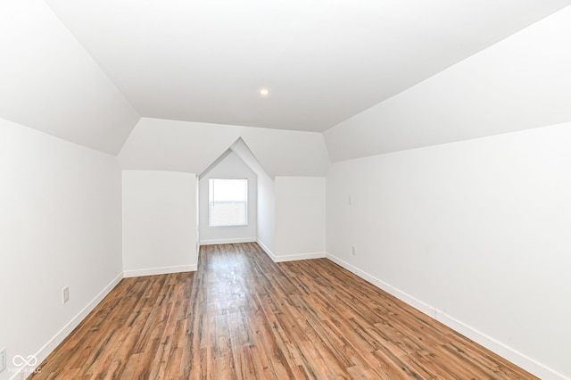 bonus room featuring lofted ceiling, baseboards, and light wood-type flooring