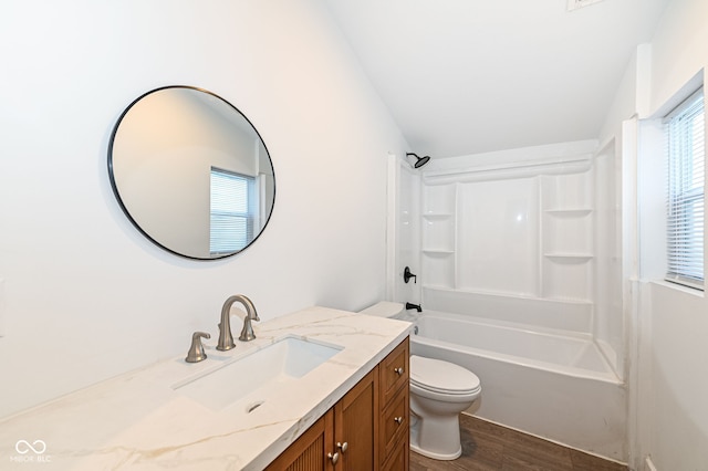 full bath featuring bathtub / shower combination, toilet, wood finished floors, and vanity