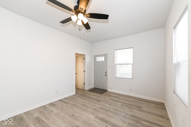 empty room featuring baseboards, a ceiling fan, and light wood finished floors