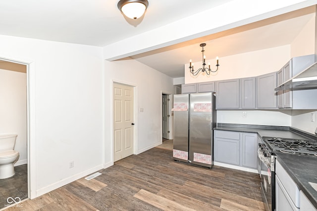 kitchen with visible vents, gray cabinets, dark countertops, dark wood finished floors, and appliances with stainless steel finishes