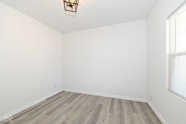 spare room with baseboards and light wood-style flooring