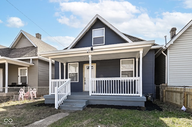 view of front of house featuring covered porch and fence