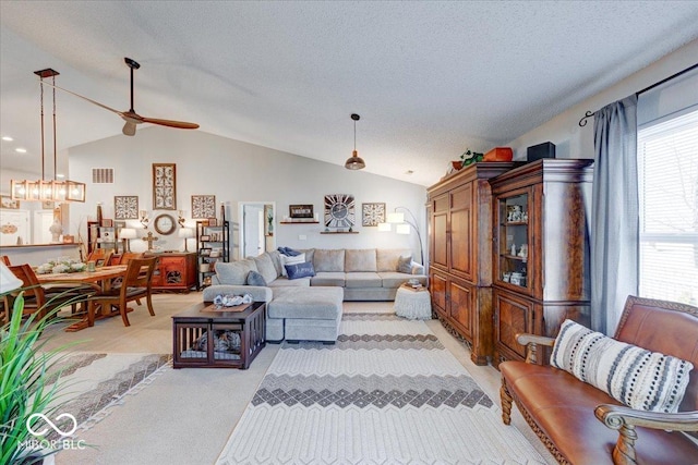 living area featuring visible vents, light colored carpet, vaulted ceiling, a textured ceiling, and a ceiling fan