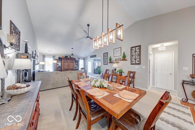 dining space featuring baseboards, light carpet, and high vaulted ceiling