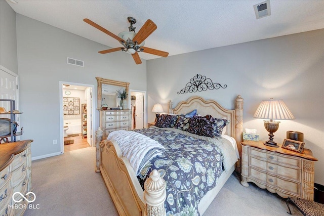 carpeted bedroom featuring visible vents, a textured ceiling, ensuite bath, and a ceiling fan