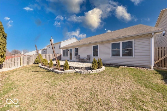 back of property featuring a yard, a patio, roof with shingles, and a fenced backyard