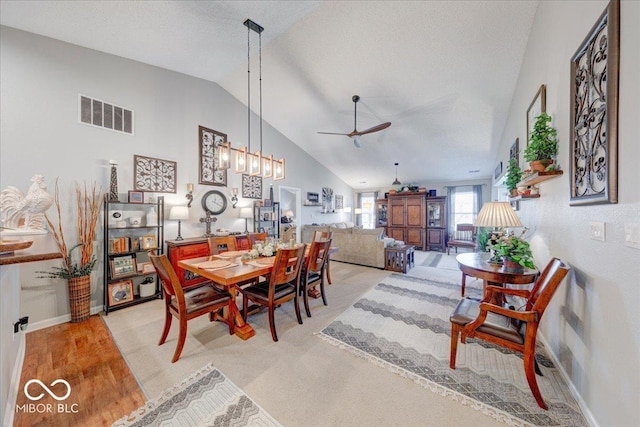 dining space with visible vents, baseboards, ceiling fan, vaulted ceiling, and a textured ceiling