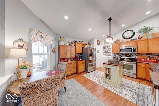 kitchen featuring light wood finished floors, recessed lighting, stainless steel appliances, hanging light fixtures, and tasteful backsplash