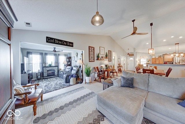 living area featuring visible vents, lofted ceiling, carpet, and a ceiling fan