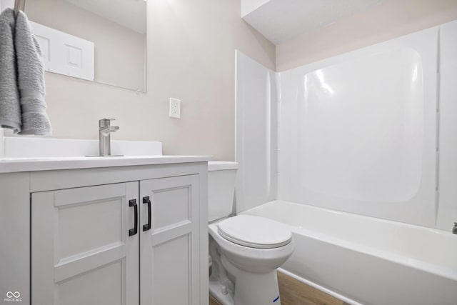 full bath with vanity, toilet, wood finished floors, and shower / washtub combination