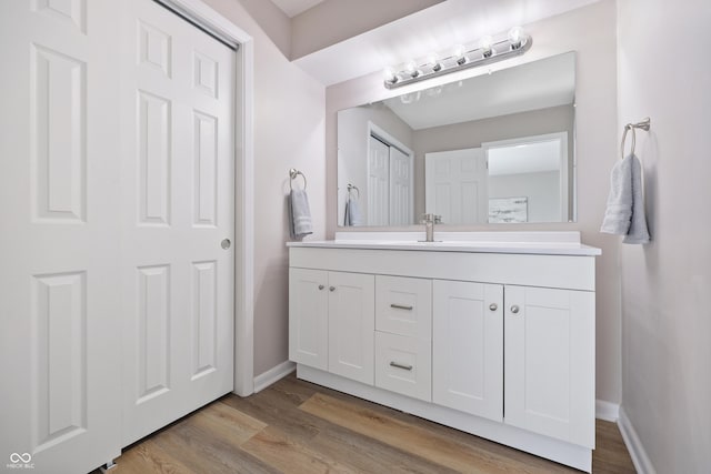 bathroom with vanity, baseboards, and wood finished floors