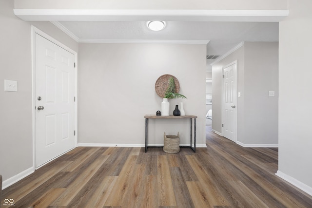 entryway featuring crown molding, wood finished floors, baseboards, and visible vents