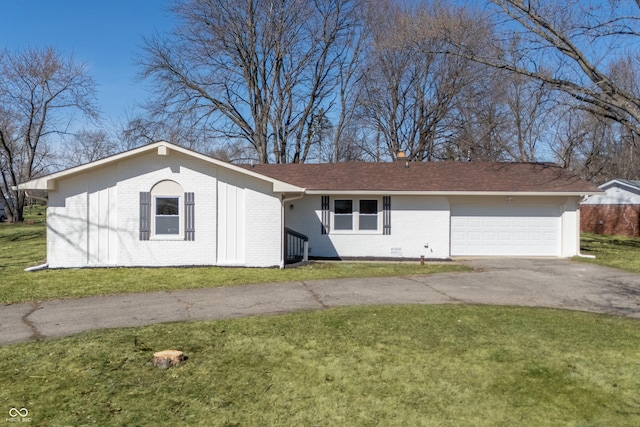 ranch-style house featuring a front yard, an attached garage, brick siding, and driveway