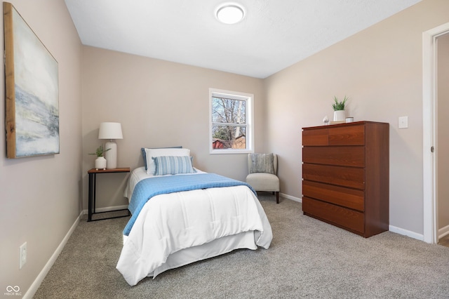 bedroom with light colored carpet and baseboards